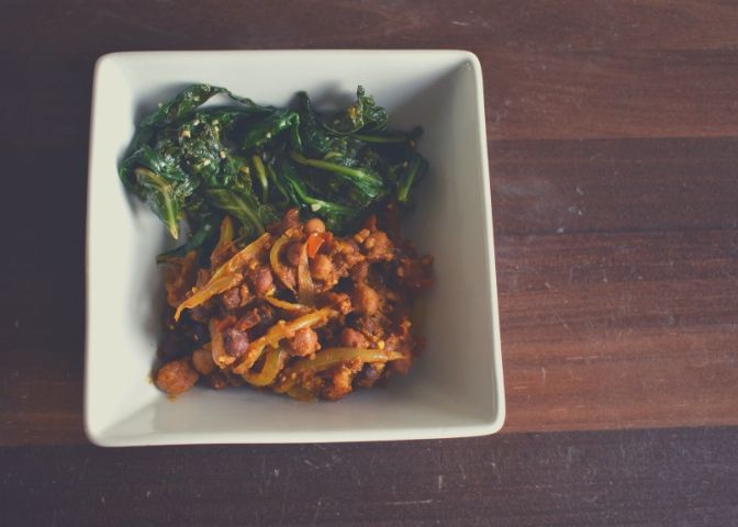 Bowl of chana masala (Indian curried chickpeas) and sautéed spicy and garlic greens