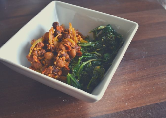 Bowl of chana masala (curried chickpeas) with spicy sautéed greens over a bed of rice