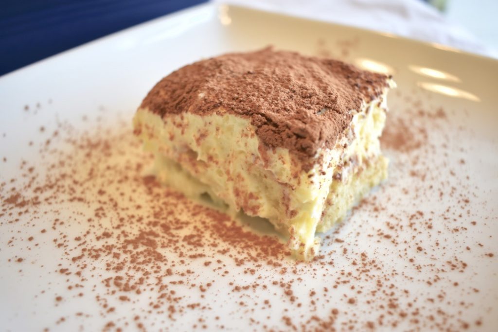 Side shot of tiramisu cake with cocoa powder