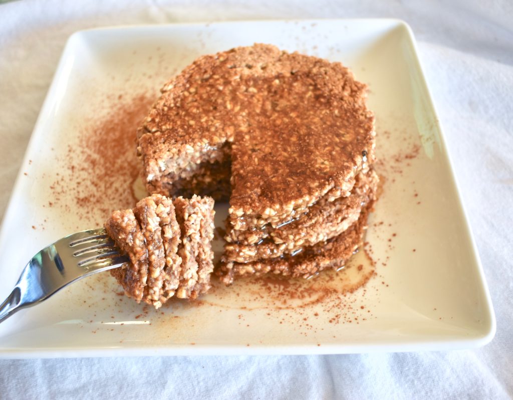 Stack of gingerbread pancakes with a bite taken out on a fork