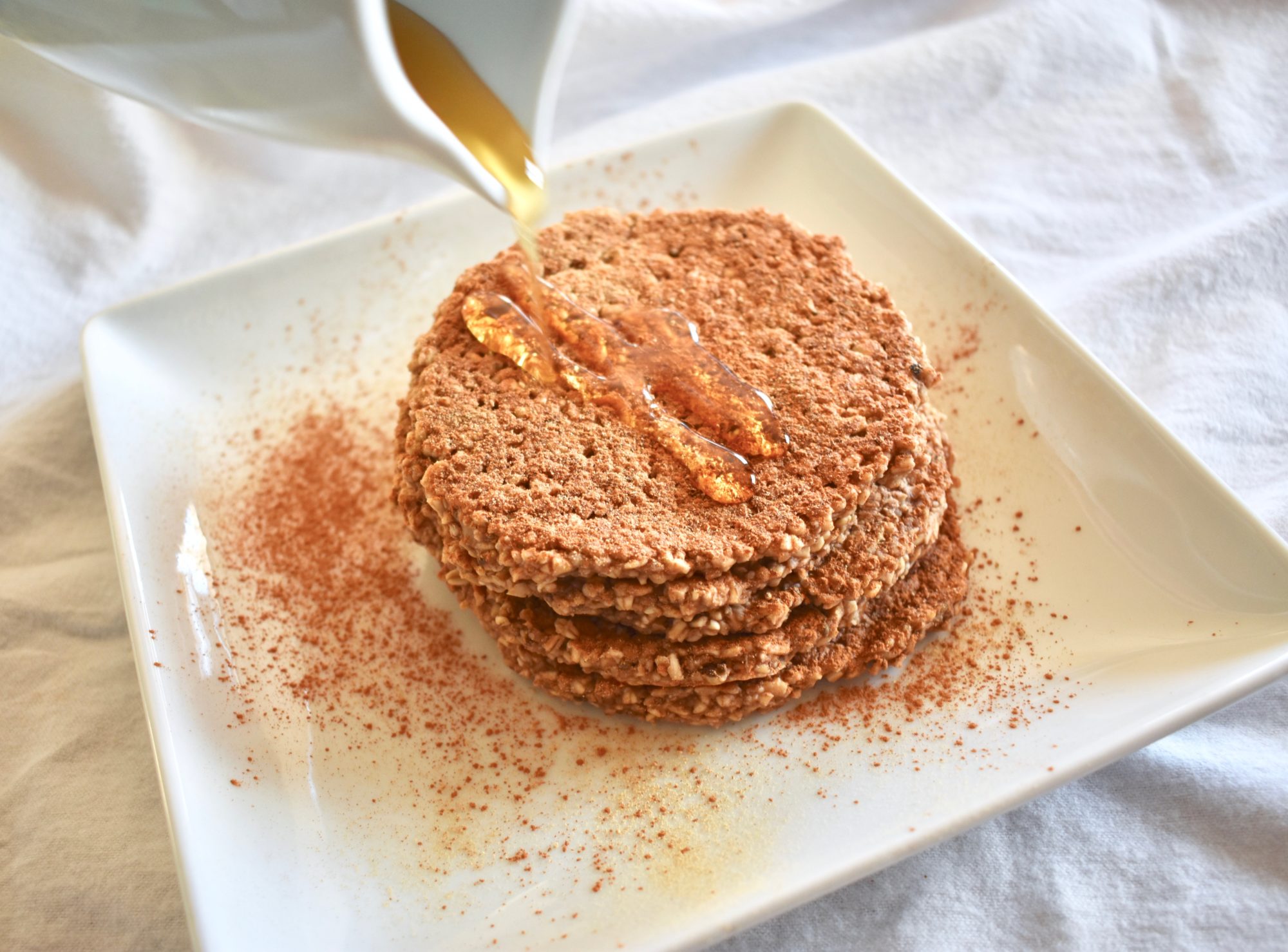 Stack of gingerbread oatmeal banana pancakes with drizzle maple syrup